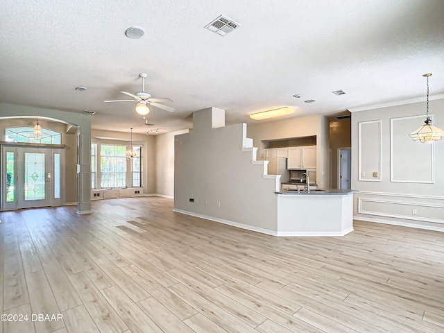 46 Coquina Point Dr, Ormond Beach, FL 32174 - unfurnished living room with ceiling fan with notable chandelier, light hardwood / wood-style flooring, a textured ceiling, and sink