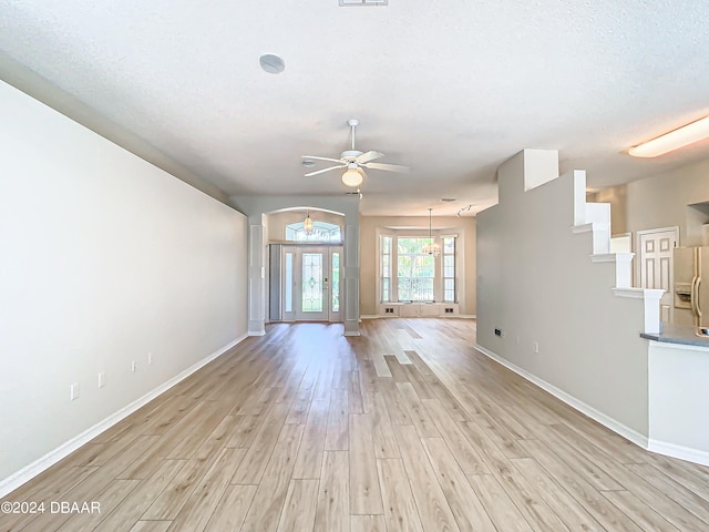 46 Coquina Point Dr, Ormond Beach, FL 32174 - unfurnished living room with french doors, ceiling fan with notable chandelier, light hardwood / wood-style floors, and a textured ceiling