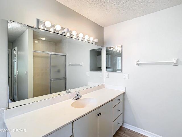 46 Coquina Point Dr, Ormond Beach, FL 32174 - bathroom with vanity, a shower with door, a textured ceiling, and wood-type flooring