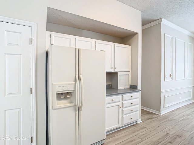 46 Coquina Point Dr, Ormond Beach, FL 32174 - kitchen featuring crown molding, light wood-type flooring, a textured ceiling, white fridge with ice dispenser, and white cabinets