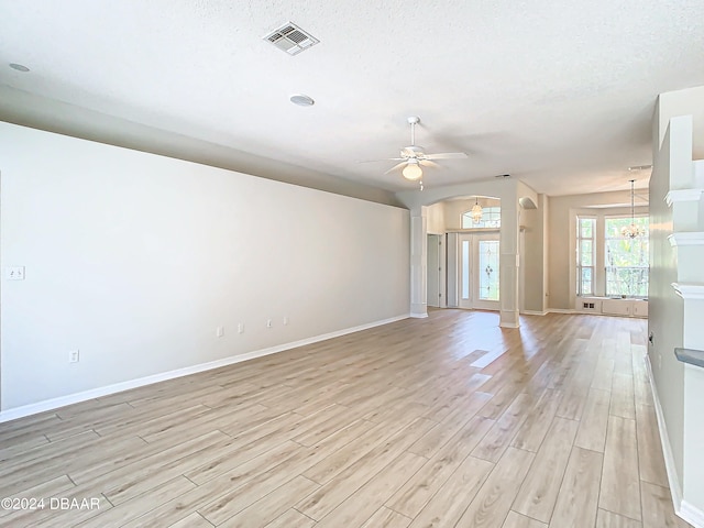46 Coquina Point Dr, Ormond Beach, FL 32174 - unfurnished room with ceiling fan with notable chandelier, a textured ceiling, and light wood-type flooring