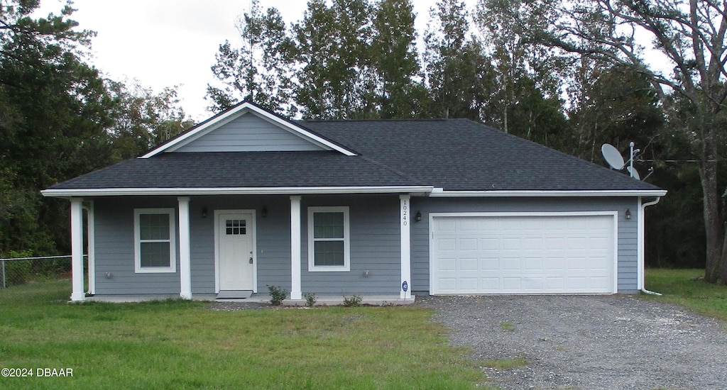 view of front of home with a front yard, a garage, and covered porch