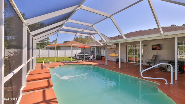 view of pool with glass enclosure, a patio area, and pool water feature