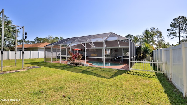 rear view of house with a lawn, a lanai, a fenced in pool, and a patio area