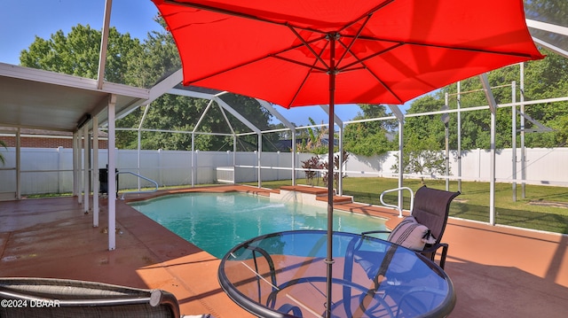 view of swimming pool with glass enclosure, a lawn, and a patio area