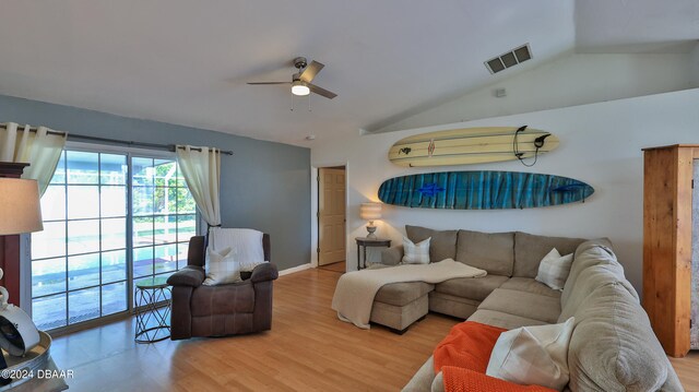 living room with ceiling fan, wood-type flooring, and vaulted ceiling