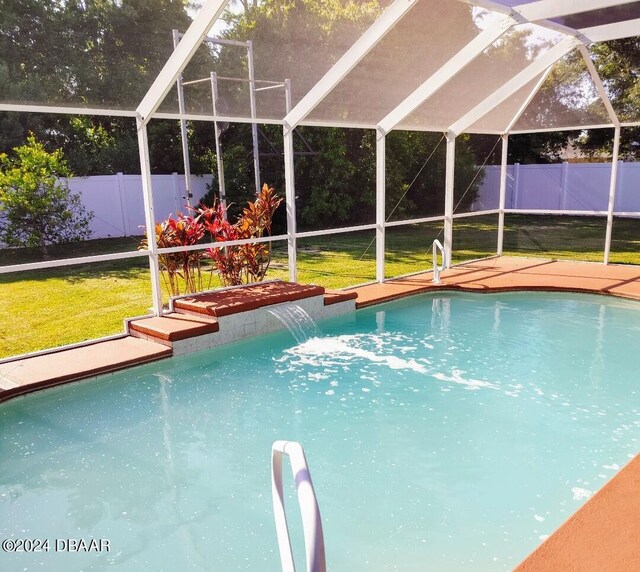 view of pool featuring a lanai, pool water feature, and a yard