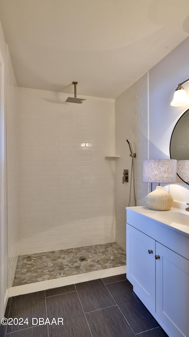 bathroom featuring tiled shower, tile patterned floors, and vanity