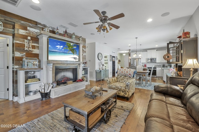 2412 Regency Park Dr, Deland, FL 32724 - living area with ceiling fan, a fireplace, hardwood / wood-style floors, and recessed lighting