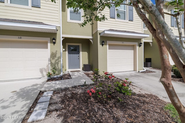 58 Bella Oaks Dr, Port Orange, FL 32129 - view of exterior entry with an attached garage, concrete driveway, and stucco siding