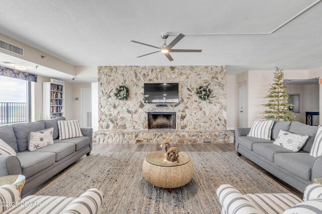 5499 S Atlantic Ave, New Smyrna Beach, FL 32169 - living room with wood finished floors, a ceiling fan, and a fireplace