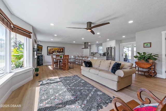 living room with light hardwood / wood-style flooring, a wealth of natural light, and a textured ceiling