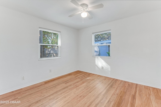 spare room with light wood-type flooring, baseboards, and ceiling fan