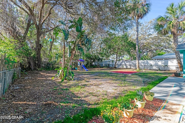 view of yard with a fenced backyard and playground community