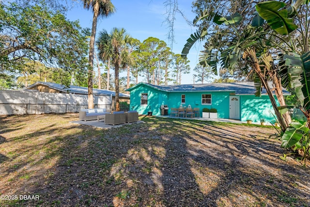 rear view of property featuring an outdoor living space, central AC unit, and fence