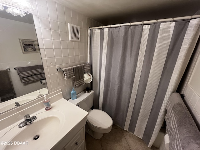 bathroom featuring vanity, backsplash, tile patterned floors, toilet, and tile walls