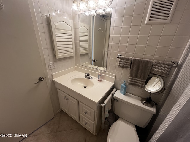 bathroom with tile patterned flooring, vanity, and tile walls