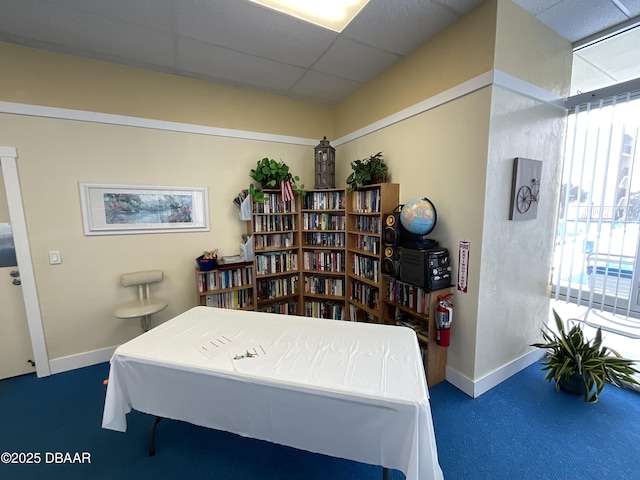 carpeted bedroom featuring a drop ceiling