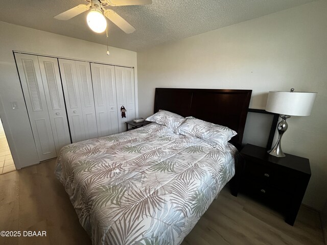 bedroom featuring ceiling fan, a closet, hardwood / wood-style floors, and a textured ceiling