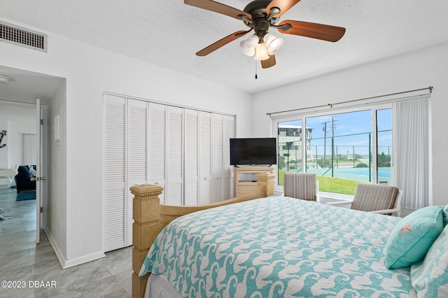3600 S Ocean Shore Blvd # 111, Flagler Beach, FL 32136 - bedroom featuring a closet, a textured ceiling, visible vents, ceiling fan, and baseboards