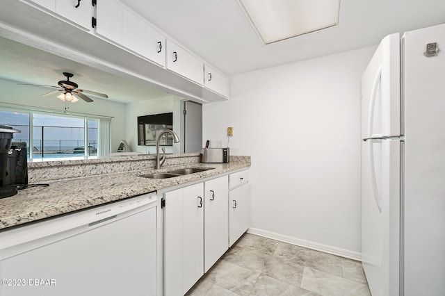 3600 S Ocean Shore Blvd # 111, Flagler Beach, FL 32136 - kitchen featuring a sink, white cabinets, baseboards, white appliances, and light stone counters