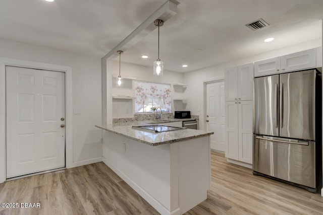 kitchen with decorative light fixtures, white cabinets, kitchen peninsula, stainless steel appliances, and light stone countertops