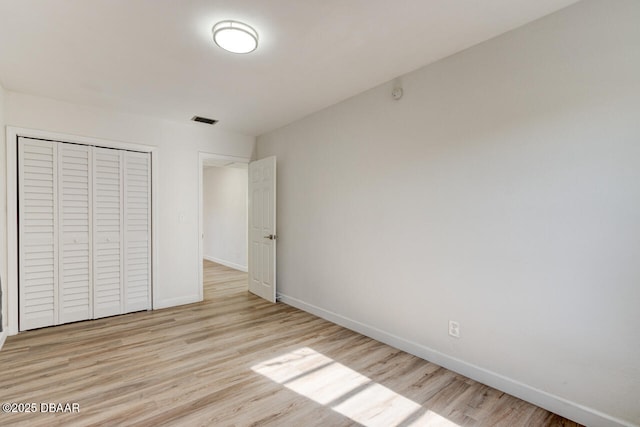 unfurnished bedroom with light hardwood / wood-style flooring and a closet