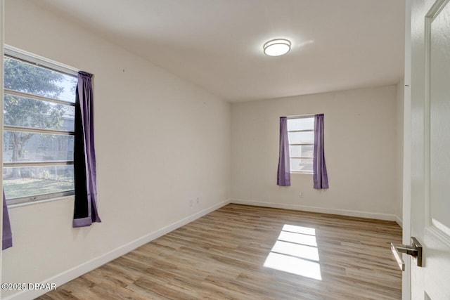 spare room with a healthy amount of sunlight and light hardwood / wood-style floors