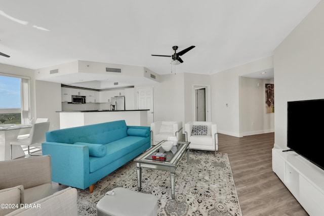 living room featuring light hardwood / wood-style flooring and ceiling fan