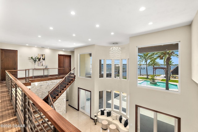 interior space with a water view, recessed lighting, and a chandelier
