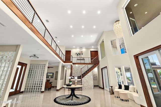 entryway featuring a high ceiling, baseboards, and stairway