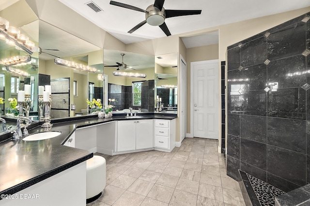 bathroom featuring visible vents, a ceiling fan, a sink, and tiled shower