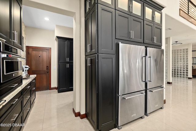 kitchen with visible vents, appliances with stainless steel finishes, light tile patterned floors, baseboards, and glass insert cabinets