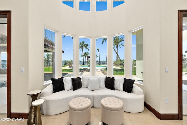 interior space with tile patterned floors, baseboards, and a high ceiling