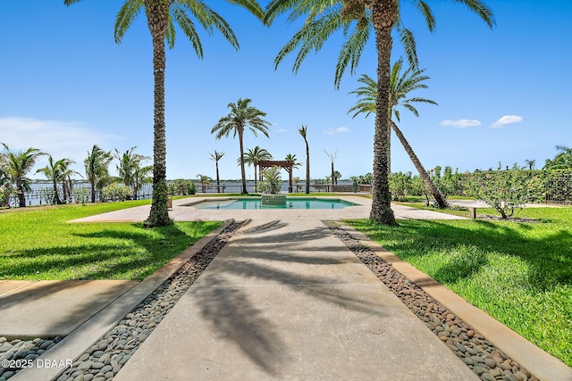 outdoor pool with a lawn and a patio area