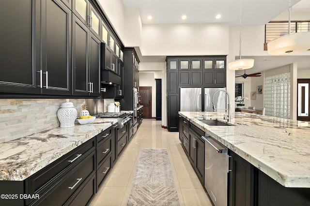kitchen with dark cabinets, appliances with stainless steel finishes, and a sink