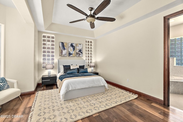 bedroom featuring dark wood-style flooring, baseboards, a ceiling fan, and a raised ceiling