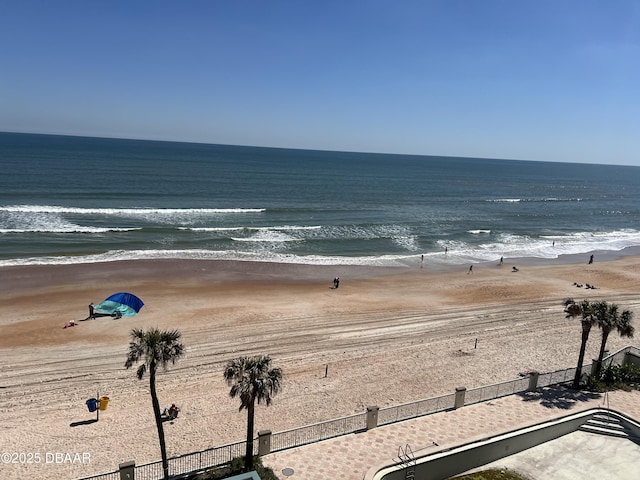 view of water feature with fence and a beach view