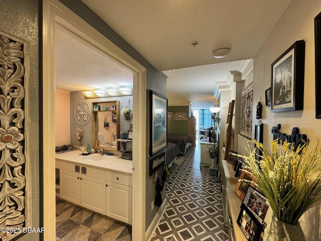 corridor with a textured ceiling and a sink