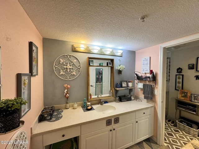 bathroom with tile patterned floors, a textured ceiling, and vanity