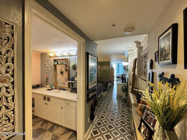 hallway with a textured ceiling and a sink