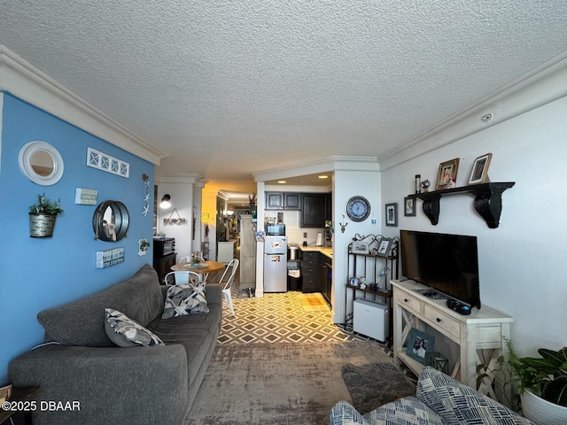 living area with ornamental molding, a textured ceiling, and decorative columns