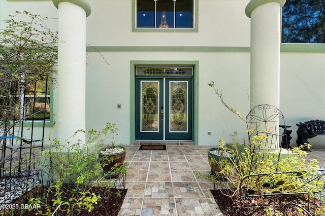 view of exterior entry with french doors and stucco siding