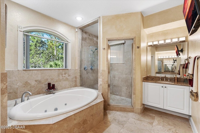 full bath featuring a stall shower, a tub with jets, and vanity