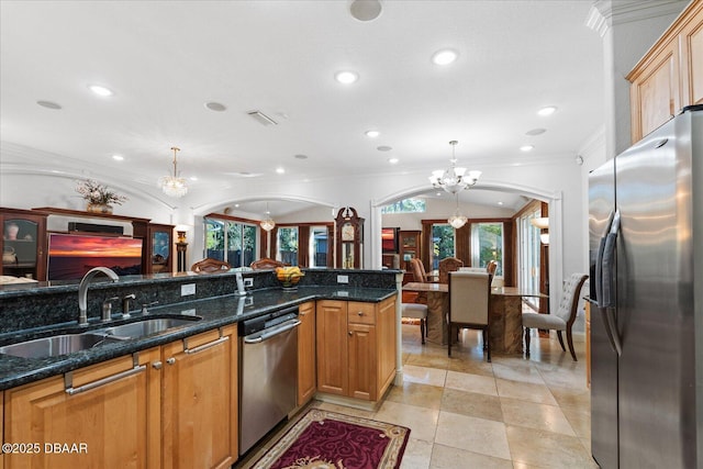 kitchen with visible vents, arched walkways, appliances with stainless steel finishes, an inviting chandelier, and a sink