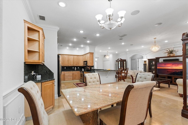 dining room with arched walkways, crown molding, visible vents, and an inviting chandelier