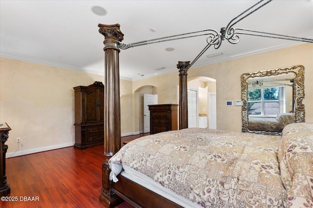 bedroom featuring baseboards, arched walkways, wood finished floors, and ornamental molding