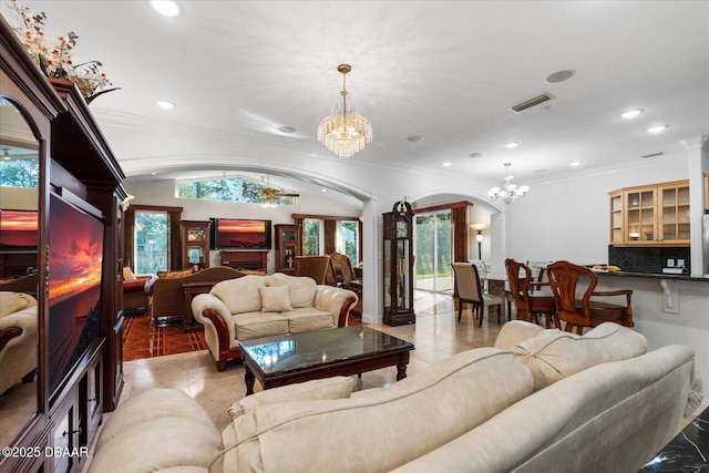 living area with light tile patterned floors, visible vents, arched walkways, crown molding, and a chandelier