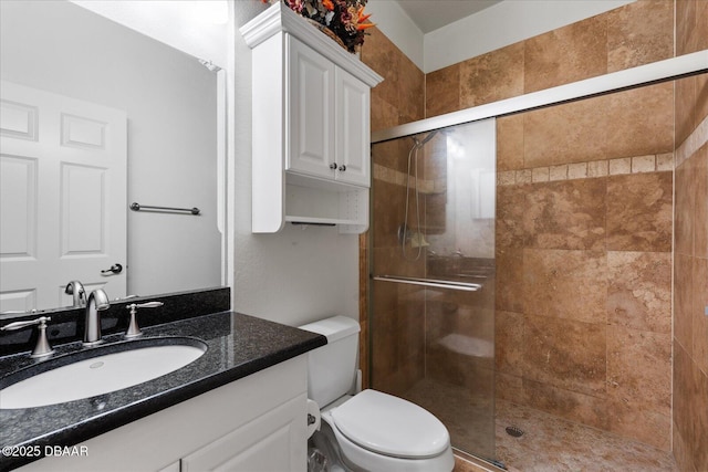 bathroom with toilet, a stall shower, and vanity