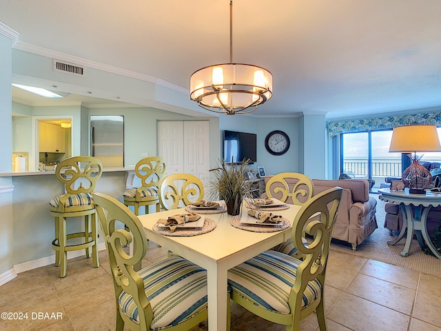 tiled dining space featuring a notable chandelier and ornamental molding